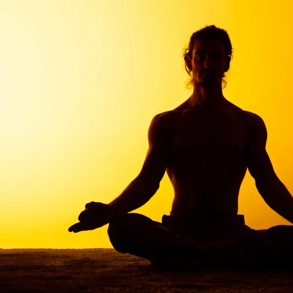 man-practicing-yoga-sunset-light
